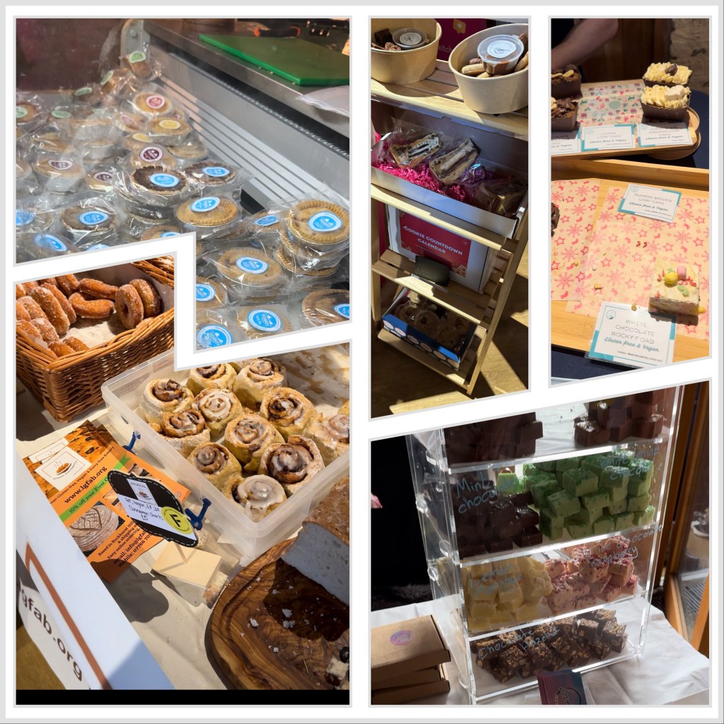 A collage of gluten-free baked goods displayed at a food event. The image features a variety of treats, including packaged tarts with coloured labels, cinnamon rolls in a plastic container, sugared doughnuts in a wicker basket, and an assortment of chocolate fudge in a clear display case. Other sections of the collage show individually wrapped treats, a wooden rack holding small cakes, and a tray of gluten-free brownies with labels. The setup includes handwritten and printed signs indicating different flavours and dietary information.