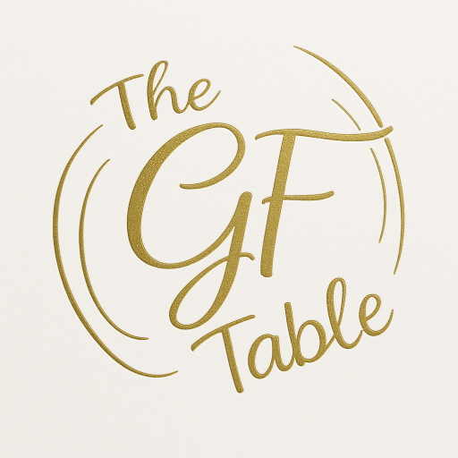 Gold-script logo for The GF Table on a white background, with a large, elegant “GF” at the centre, surrounded by curved lines and flanked by “The” above and “Table” below.